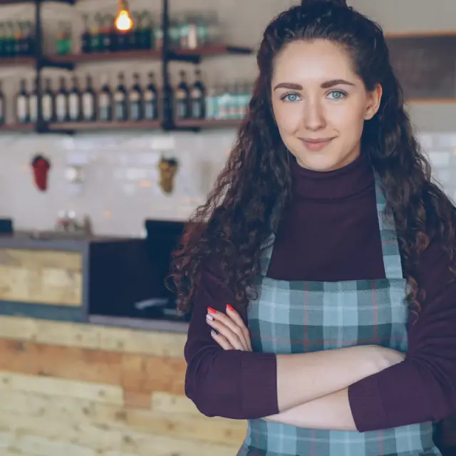 Smiling café owner standing behind her counter